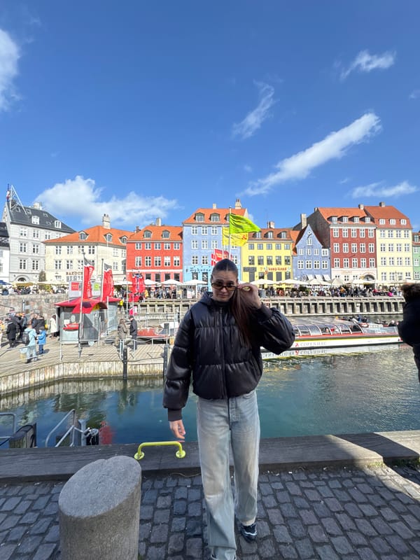 Tourists gather at sunny Nyhavn harbor in Copenhagen