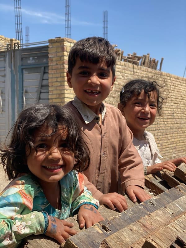 Construction workers water bricks at dawn in Kandahar