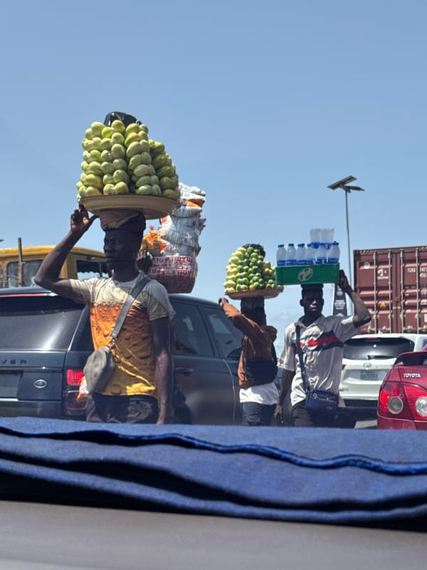Street vendors sell fruit between traffic lanes in Ilado