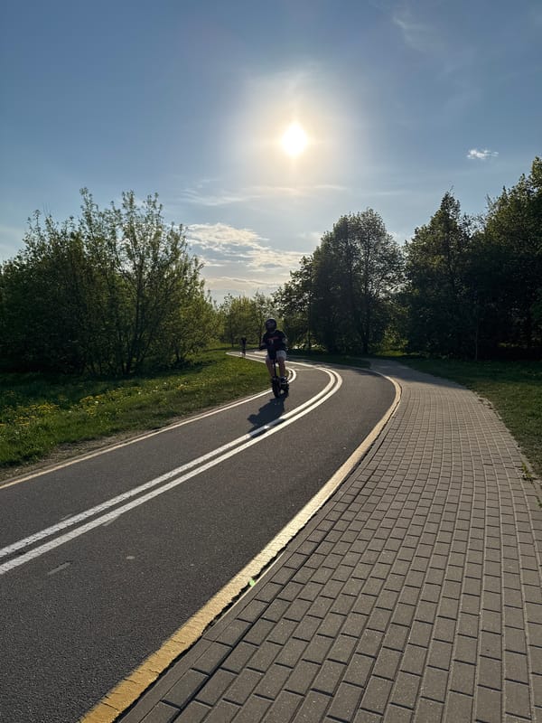 Electric scooter rider travels tree-lined path in Minsk