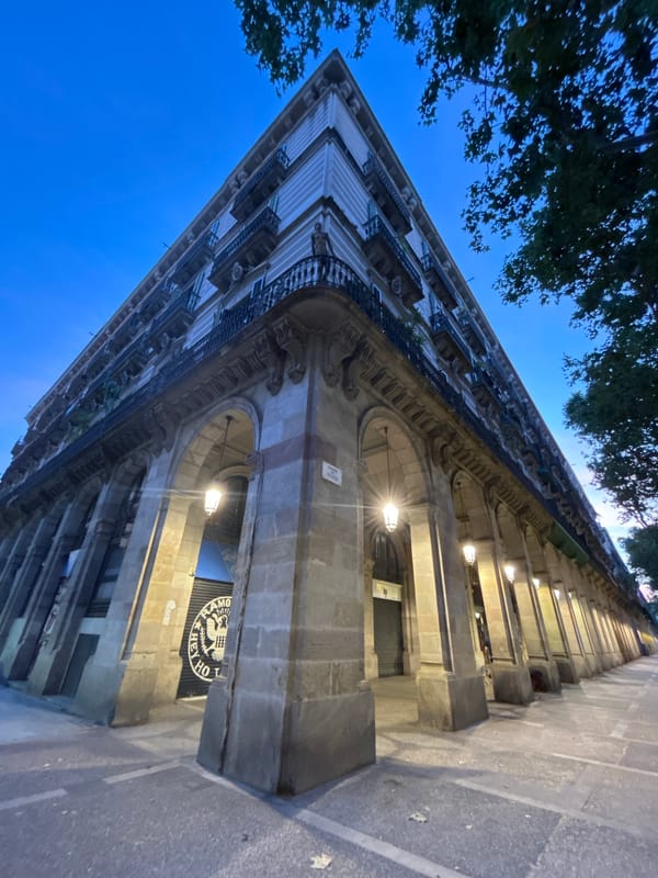 Gothic facades and arched colonnades in evening Barcelona