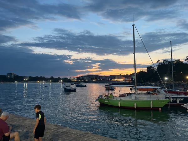 Dusk at Primorsko's harbor pier, station wagon parked at water's edge