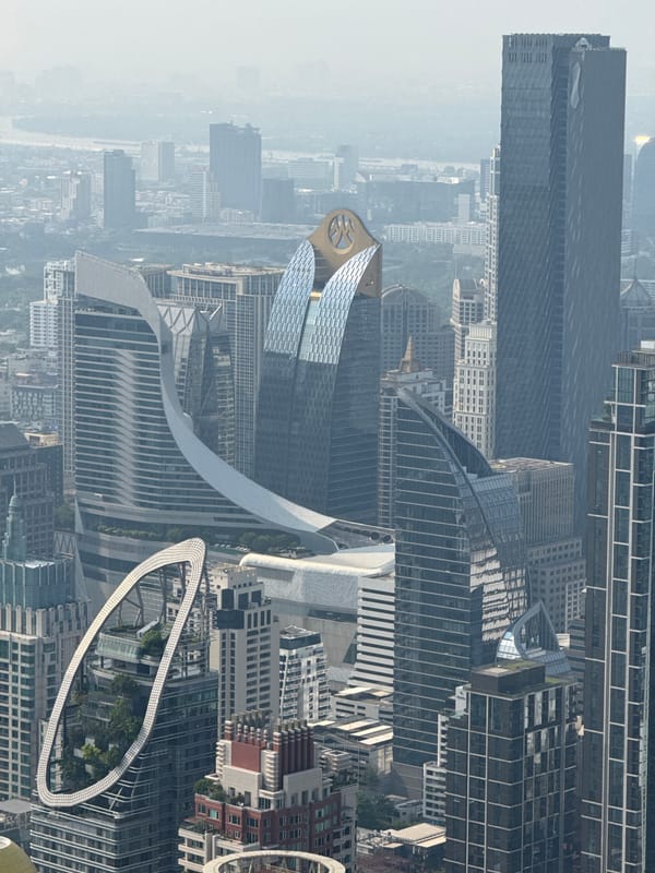 Woman dines with Bangkok skyline view at elevated restaurant