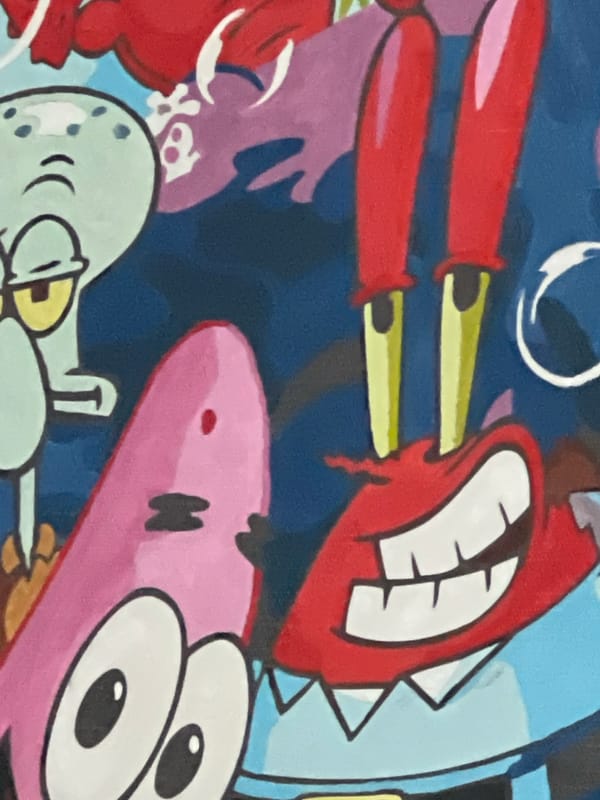 SpongeBob painting and Smurf plush toy, up close