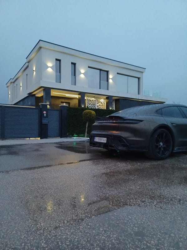 Car parked outside modern house on wet Topoli street