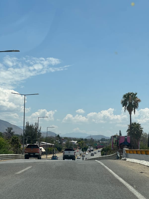 Traffic flows through Tlalixtac de Cabrera under cloudy skies