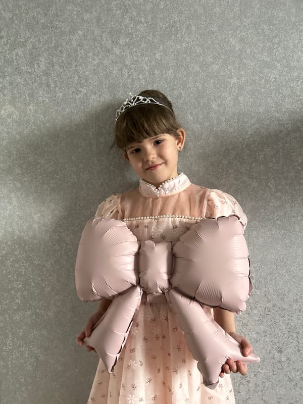 Girl in pink dress draws and plays in Klin