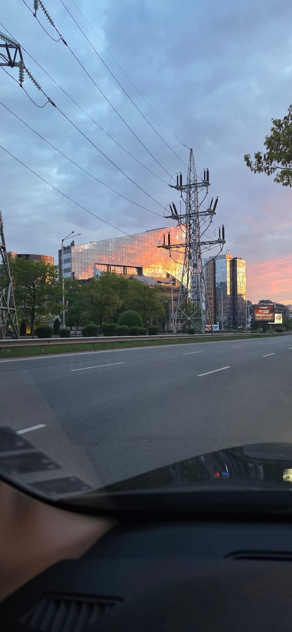 Early morning drive captures mirrored building reflecting sunset in Sofia