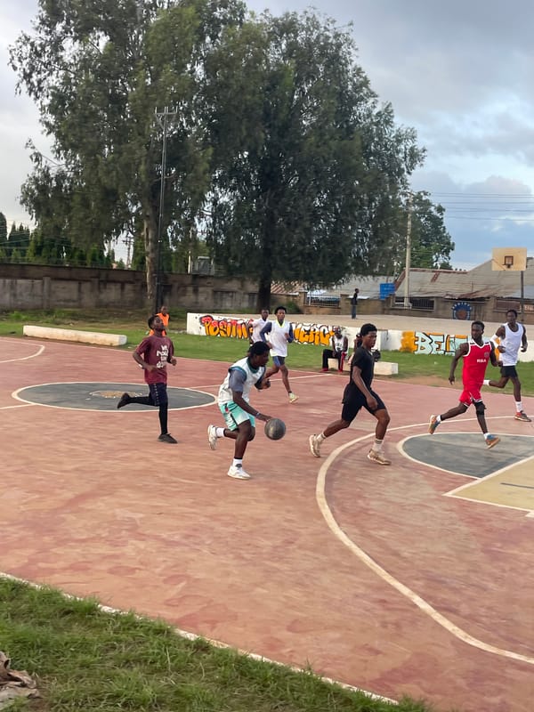 Pickup basketball on a red outdoor court in Gura Top, Nigeria