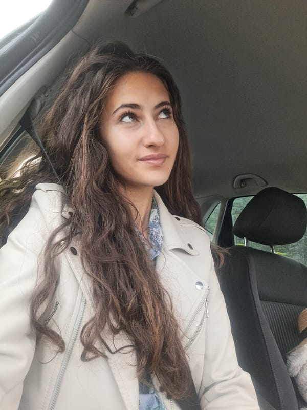 Woman gives thumbs-up in car with teddy bear, Lozen