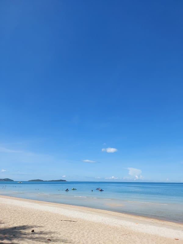 Calm morning at Chaweng Noi beach, red cup in hand