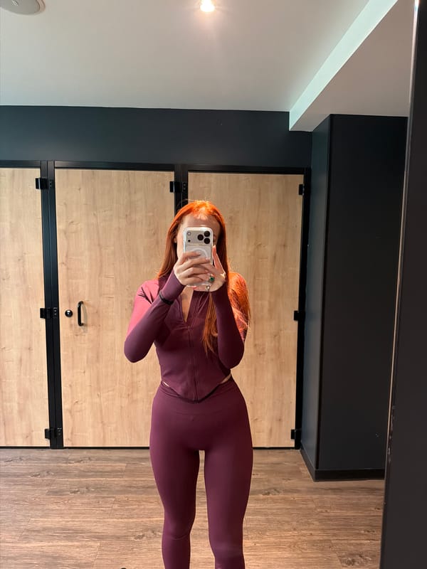 Woman takes gym selfie in burgundy activewear in Paris