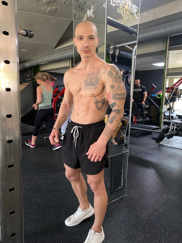 Tattooed fitness enthusiast poses at Pleven gym