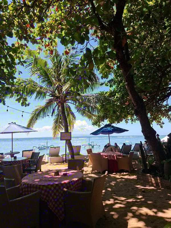 Beachside dining scenes with Buddha sculptures documented in Denpasar