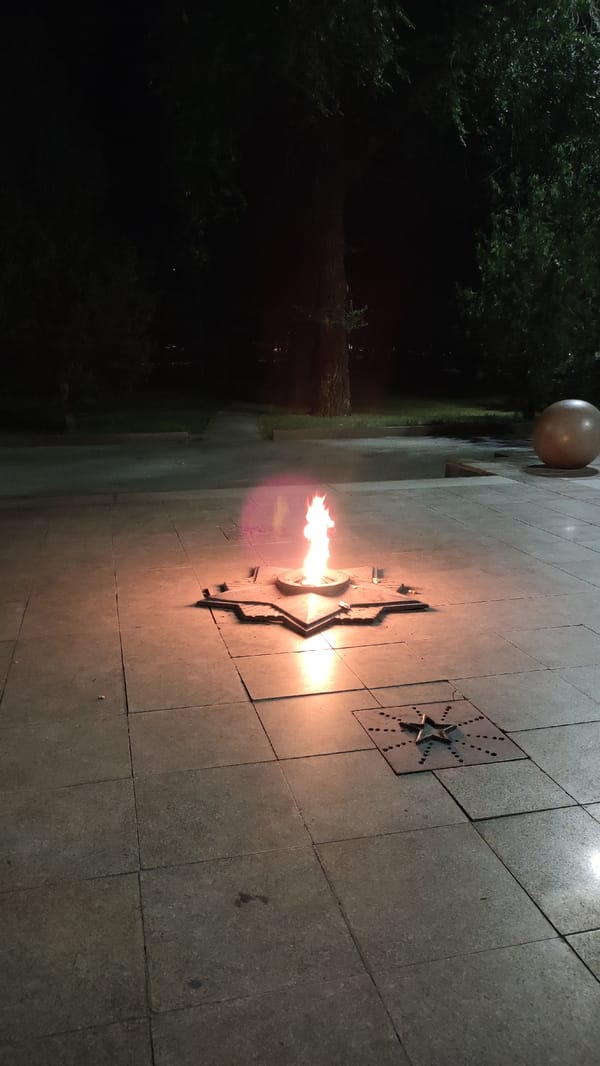 Evening out: memorial flame, city flowers, and a gas station stop