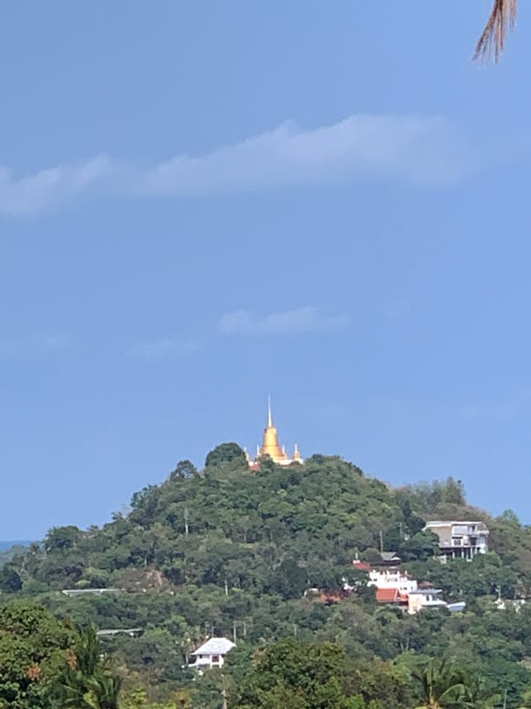 Golden temple overlooks coastal landscape in บ้านบางรักษ์, Thailand