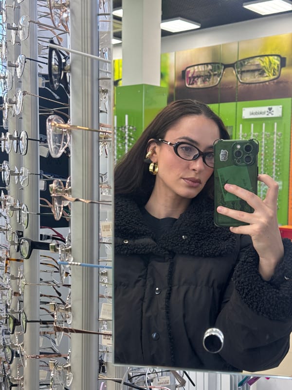 Woman takes selfie on Krasnoyarsk sidewalk near school