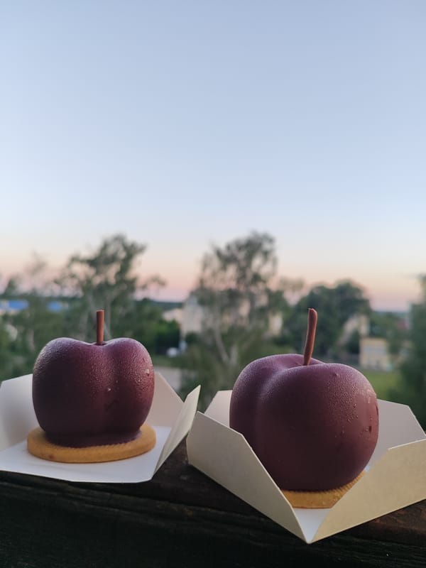 Fruit-shaped mousse desserts enjoyed against a dusk city backdrop