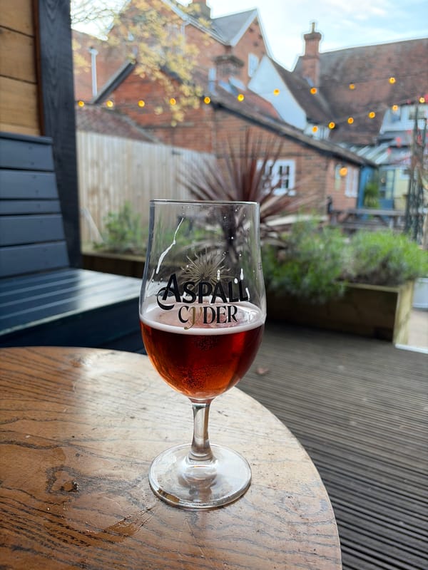 Half-full glass of Aspall Cider observed in East Suffolk