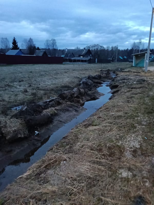 Rural drainage ditch and smiling woman documented same location