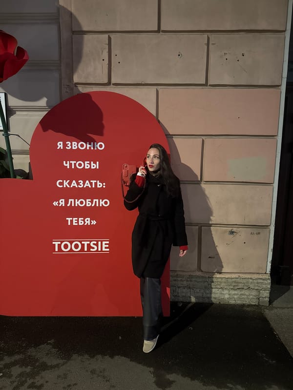 Woman poses with red props during nighttime photoshoot in Saint Petersburg