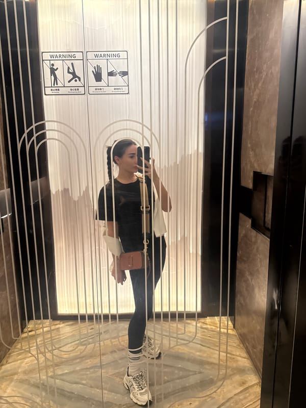 Woman takes selfie at warning-labeled doors in Yiwu