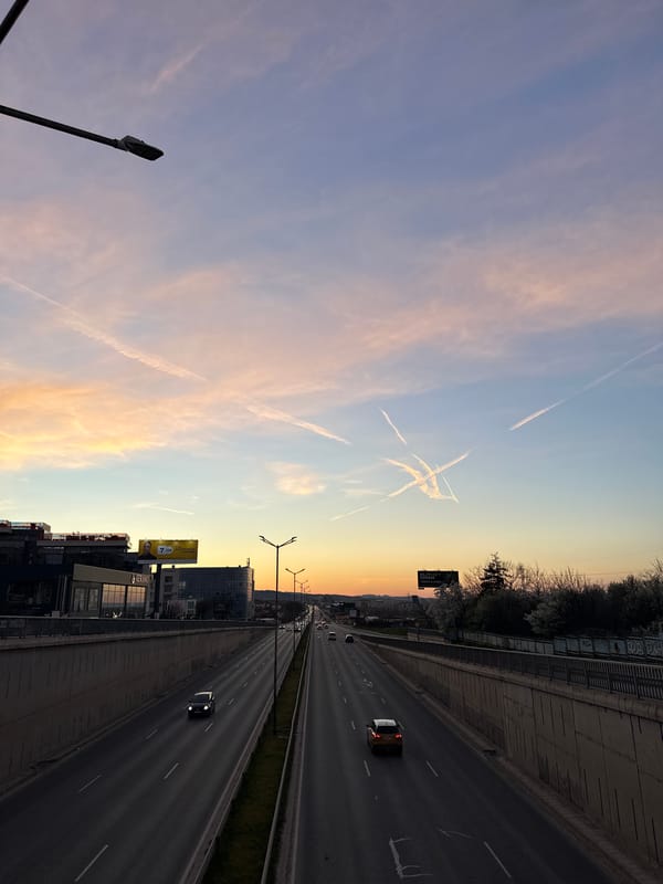 Evening traffic flows on Sofia highway under vapor-streaked sky