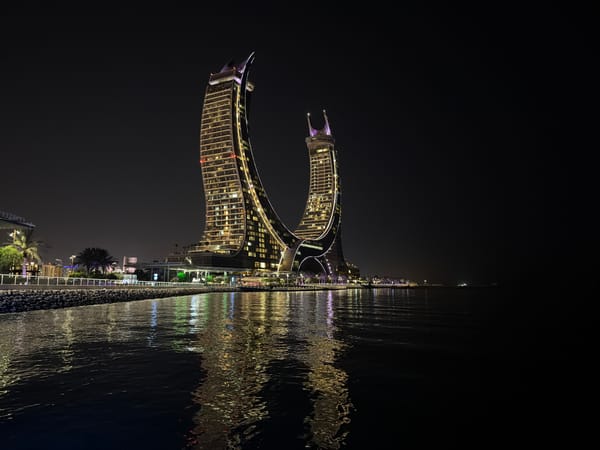 Nighttime waterfront district showcases illuminated towers and entertainment venues