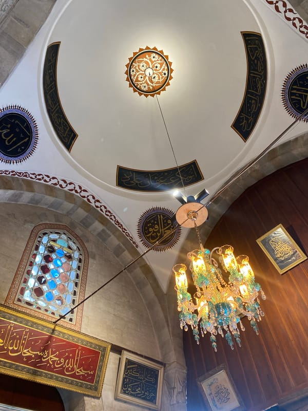 Visitor documents historic Karatay Madrasa architecture and Islamic artifacts