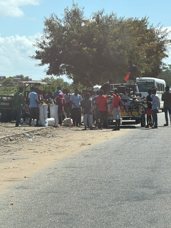 Crowd surrounds possibly overloaded vehicle in Pemba, Mozambique