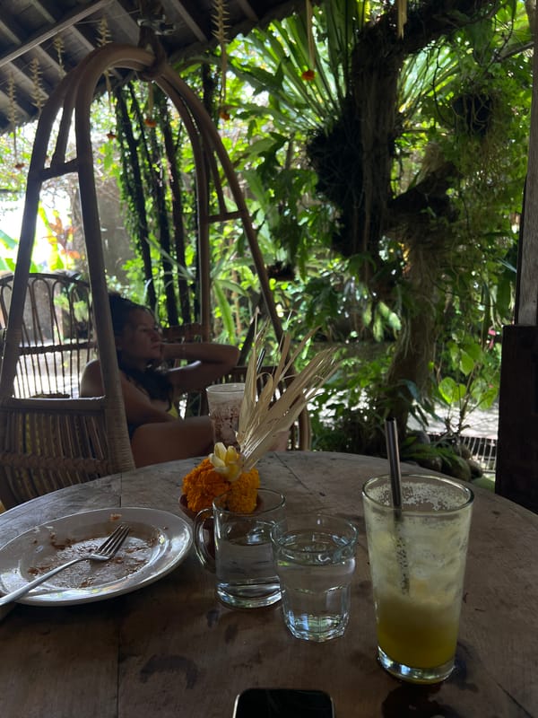 Woman sits at outdoor table in Ubud early morning