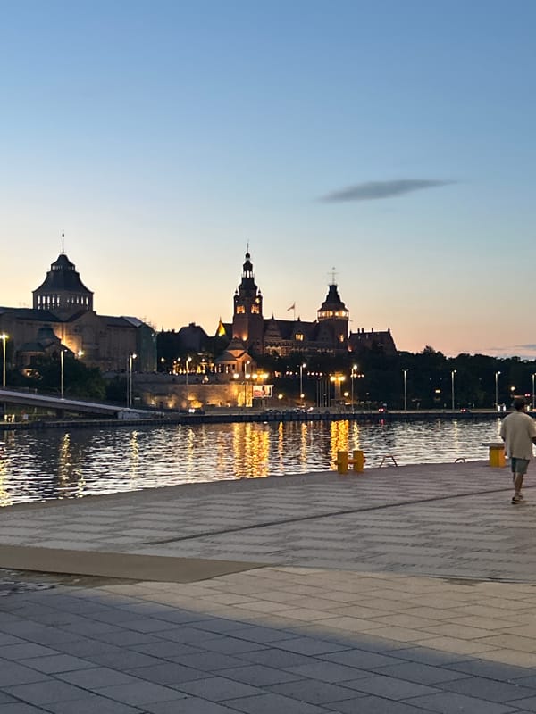 Szczecin waterfront at dusk — boats, spires, and science center