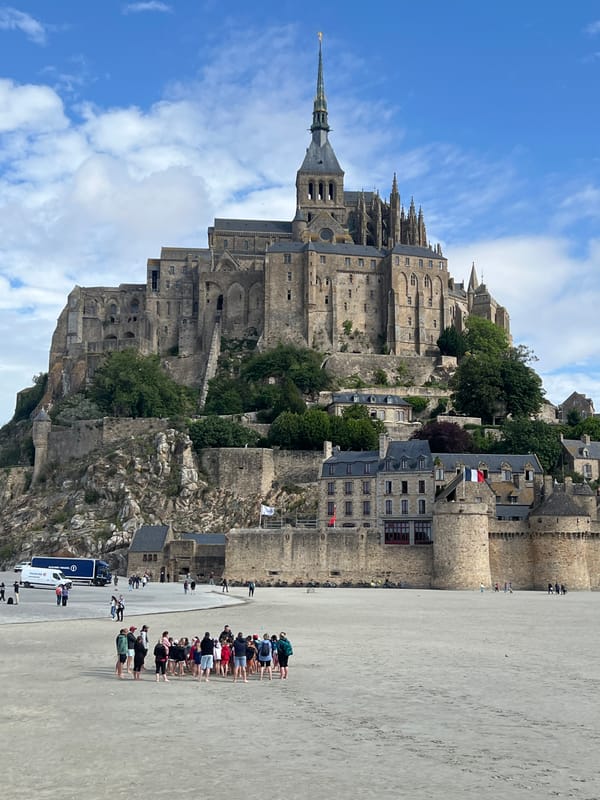Morning tourists explore Mont Saint-Michel's medieval streets and tidal plains