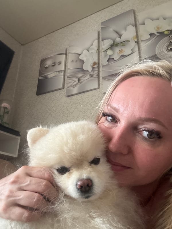 Pomeranian and owner share a lazy afternoon in bed