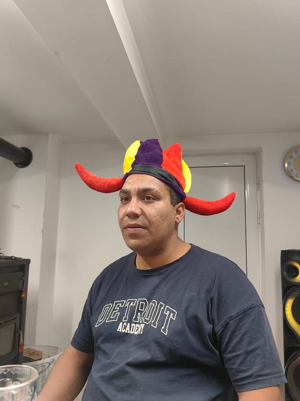 Man in jester hat dances in Bulgarian room