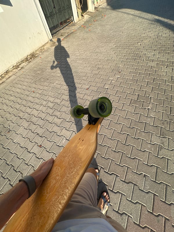 Longboard and long shadows on a paved Fethiye walkway