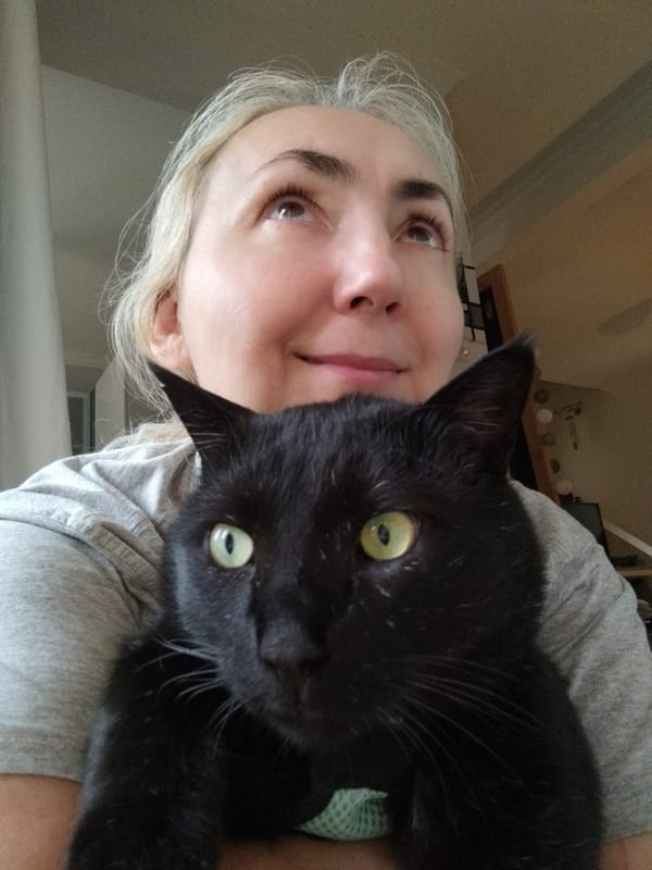 Woman holds black cat in casual portrait moment