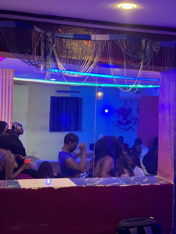 Late-night club scene at a neon-lit lounge in Durumi, Nigeria