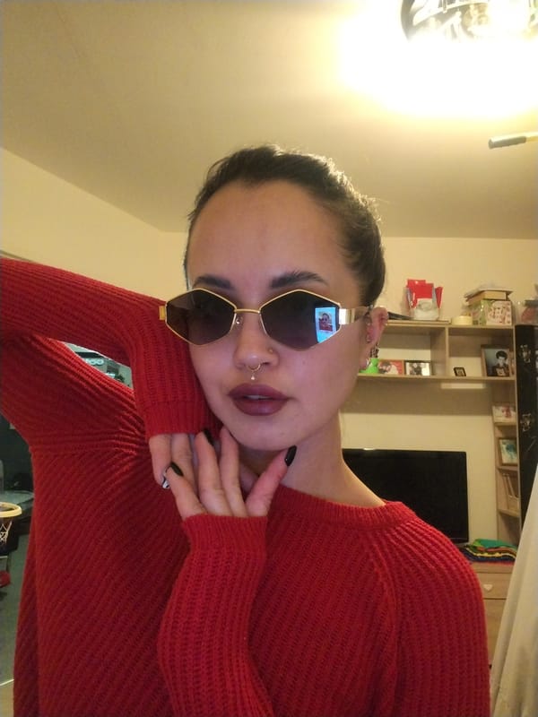 Woman photographed indoors with distinctive styling and makeup
