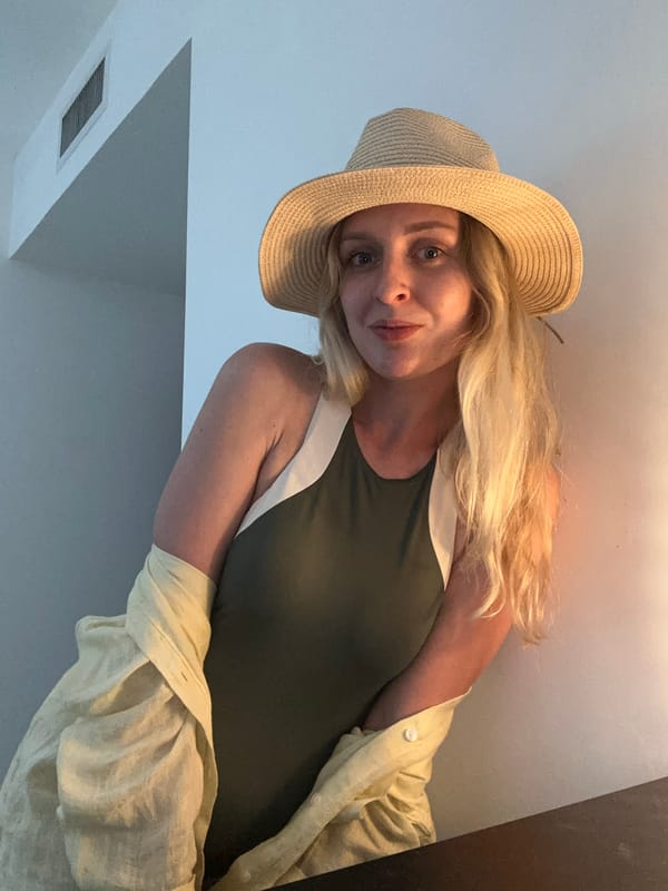Woman in straw hat photographed smiling at camera