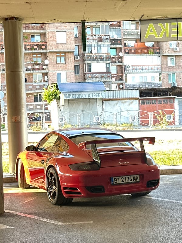 Red Porsche 911 Turbo parked under concrete cover in Veliko Tarnovo