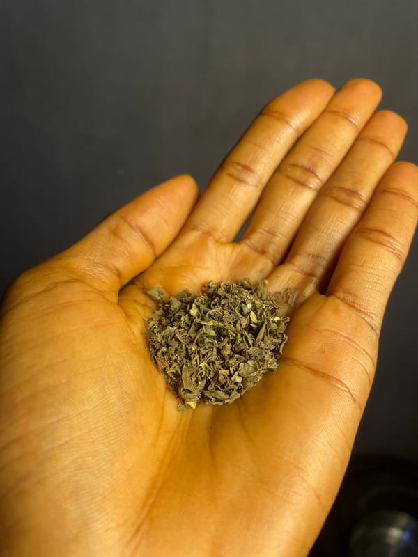 Person prepares rolled cigarette with herbs in Nkpor