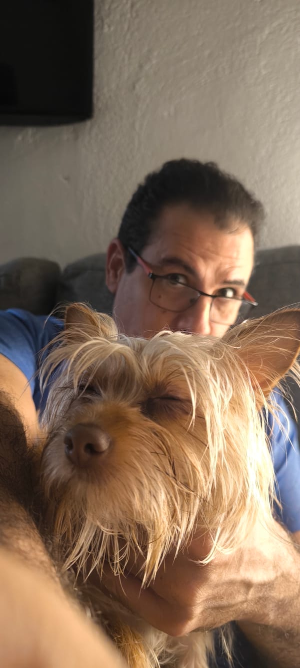 Man and small dog photographed together indoors in Ripollet