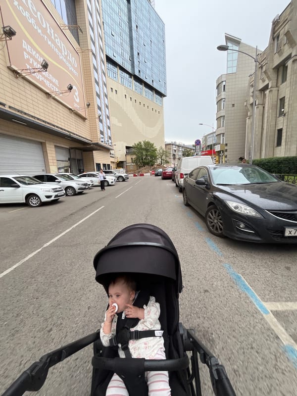 Baby in stroller on a paved road in Novaya Usman