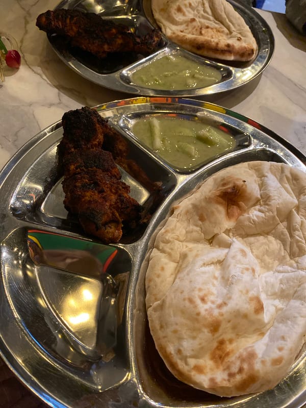 Traditional meal served in metal trays at Dhaka restaurant