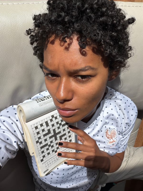 Person solves crossword puzzle on sofa in Champs-sur-Marne