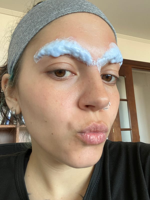 Person applies blue skincare treatment in Gijón selfie session