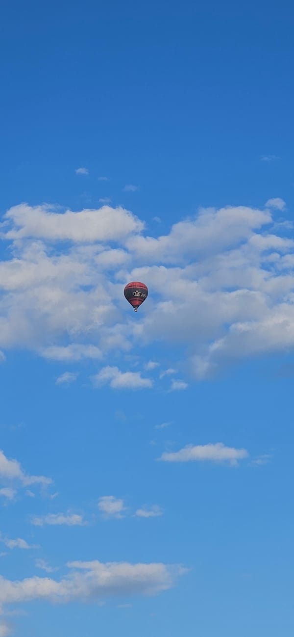 Hot air balloon rises over Hévíz on a sunny afternoon
