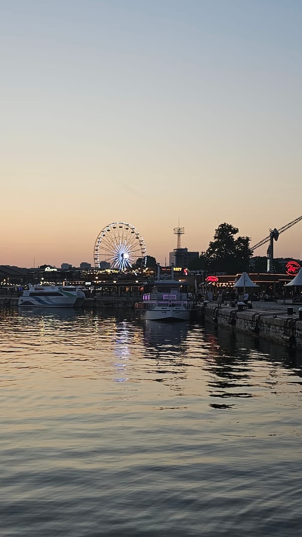 Varna harbor at dusk: Ferris wheel, sailboats, and a glowing sky