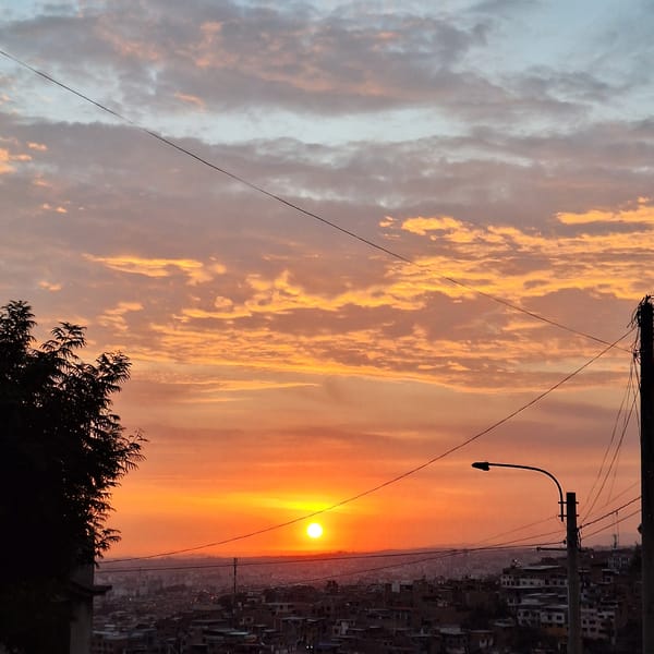 Fiery sunset illuminates dense housing in Mariano Melgar, Peru